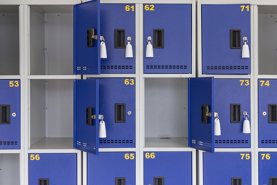 Filas de lockers metálicos color azul oscuro con números color mostaza