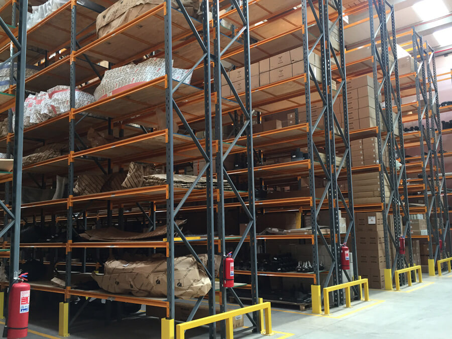 Racks Metálicos Azules y Naranjos con Cajas y Mercadería en Bodega