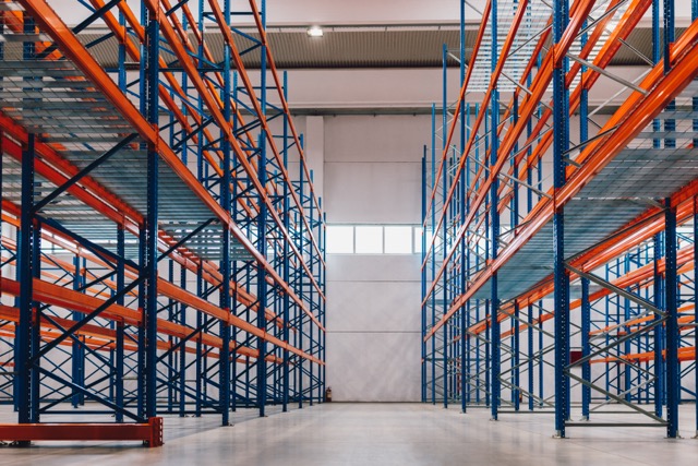 Bodega de Almacenamiento con Racks Metálicos color azul y rojos vacíos